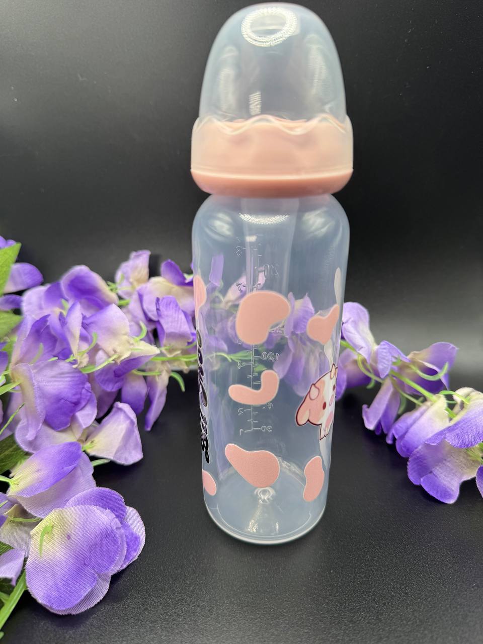 Close-up of Lil Moo pink cow ABDL baby bottle featuring pink cow spots and adult-sized nipple