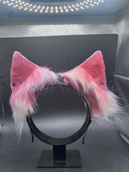 red and white fluffy cat ears on a black headband against a dark background