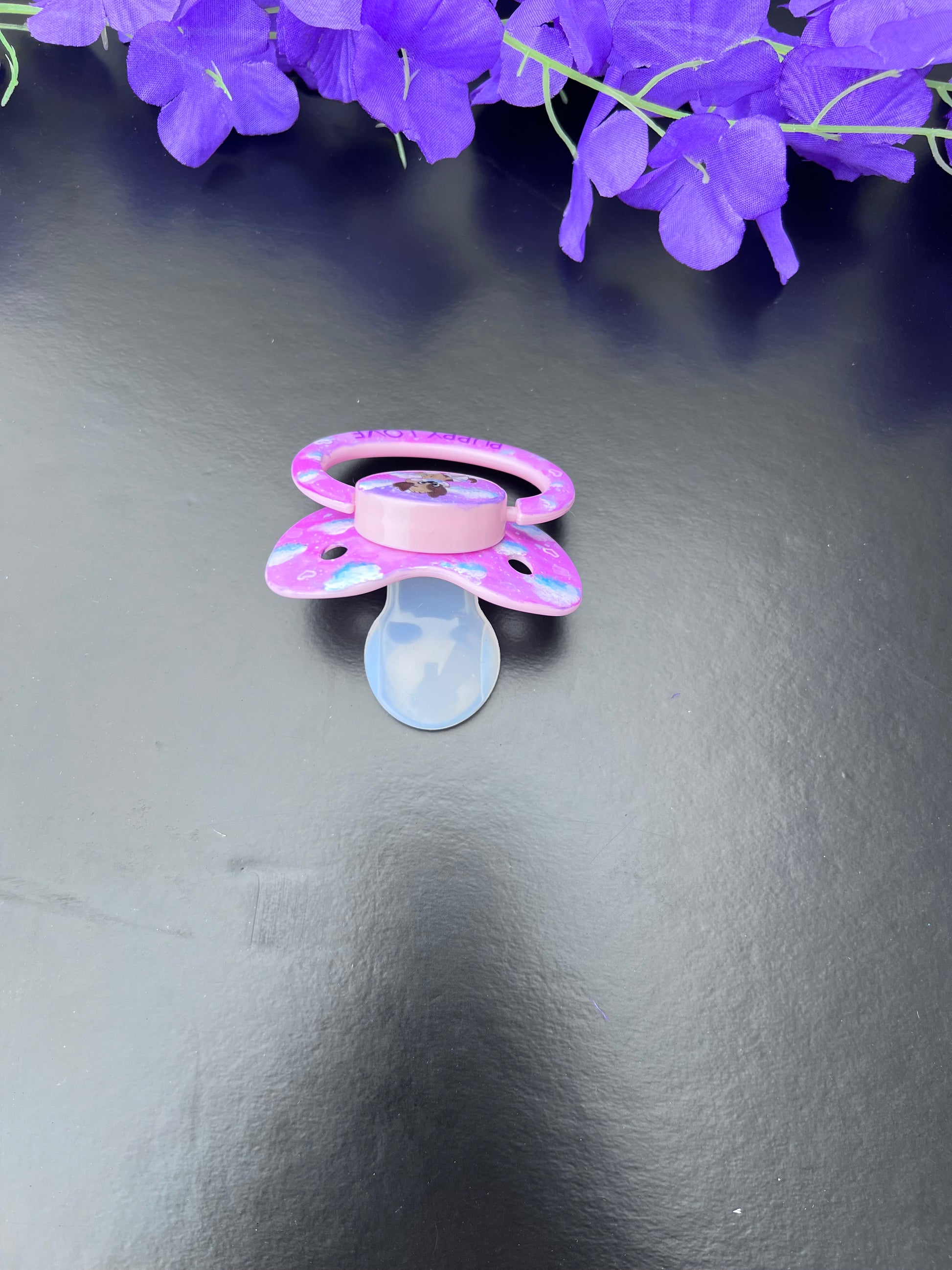 baby pink adult binkie with hand painted design of clouds and puppy center