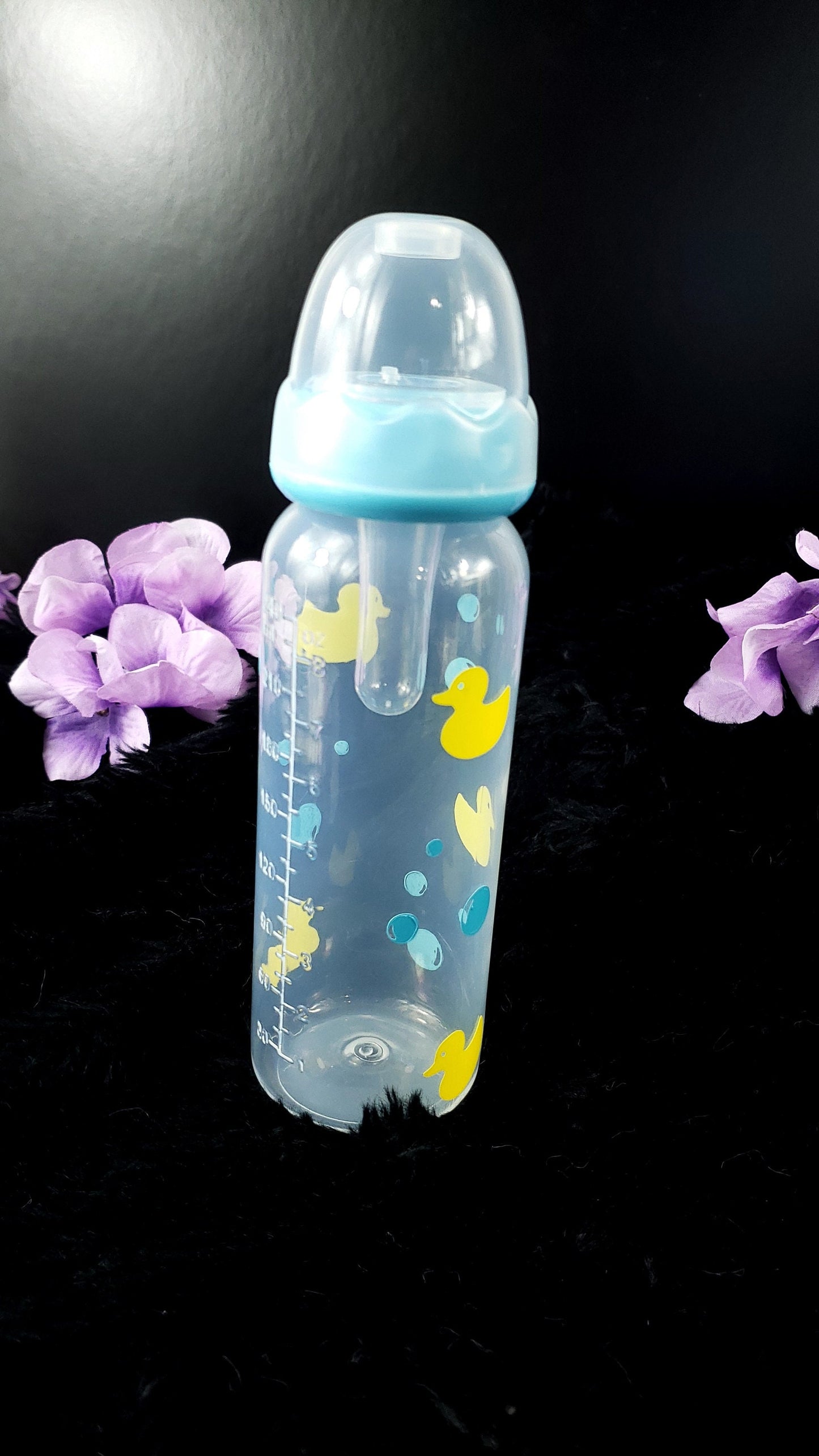 An 8oz adult baby bottle featuring a playful design with yellow ducks and blue bubbles, creating a fun and whimsical bath-time-inspired theme.