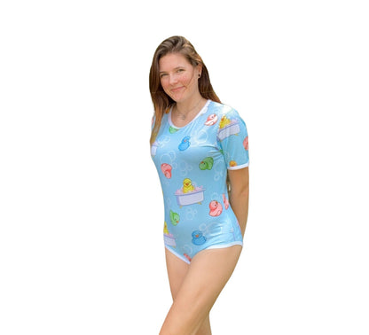 A blue adult baby onesie featuring a playful design with rubber ducks and bubbles, creating a cheerful and bath-time-inspired theme.