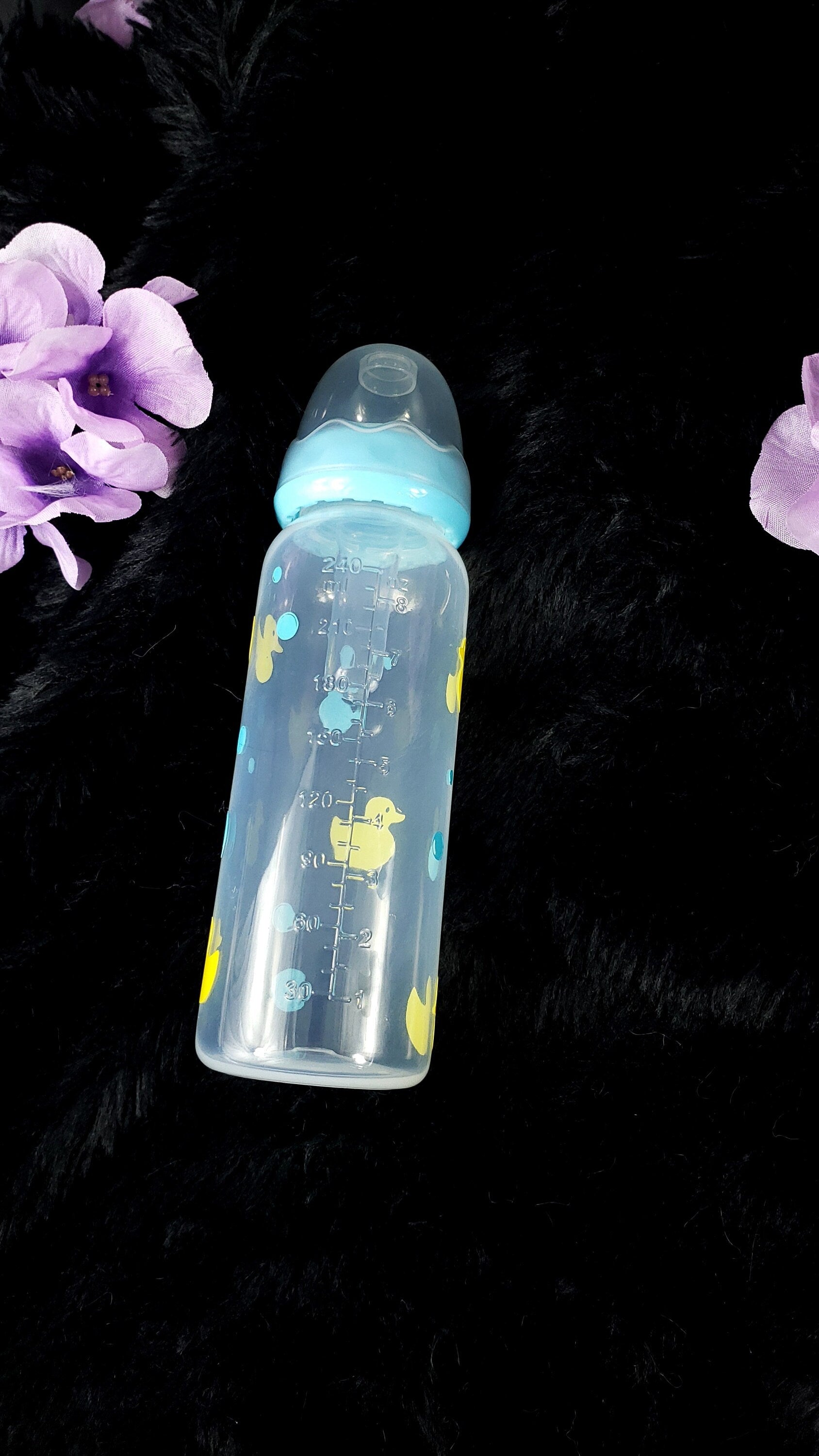 An 8oz adult baby bottle featuring a playful design with yellow ducks and blue bubbles, creating a fun and whimsical bath-time-inspired theme.