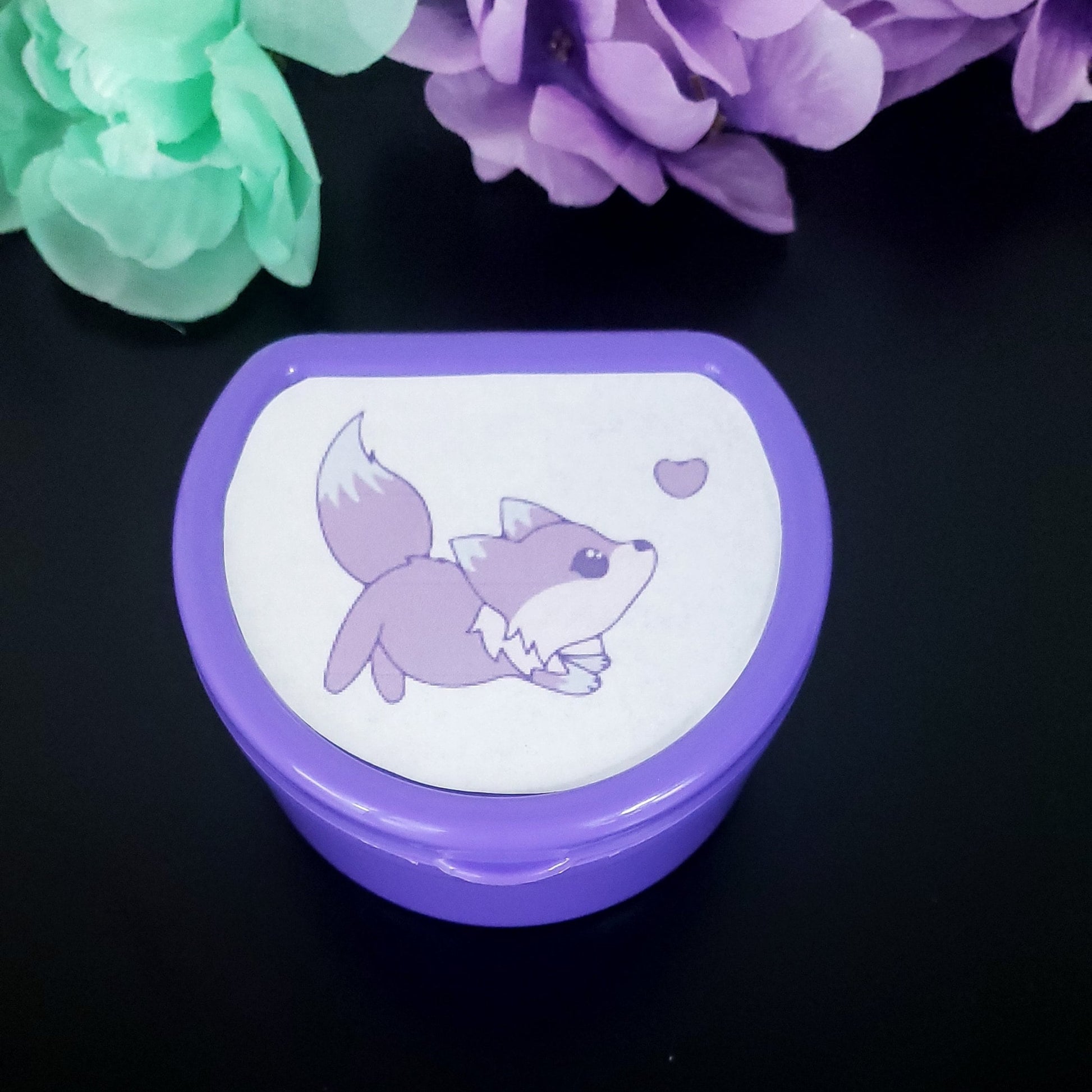 Purple pacifier case featuring a purple galaxy kawaii fox jumping towards a purple heart