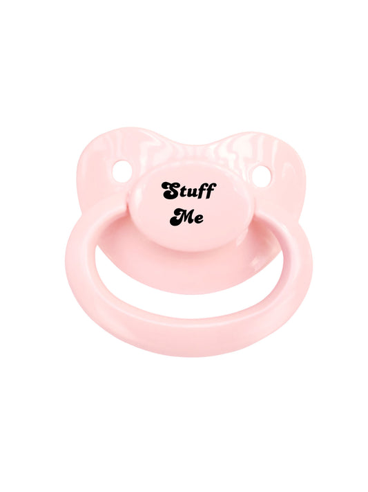 baby pink adult pacifier with the text "Stuff Me" in the center