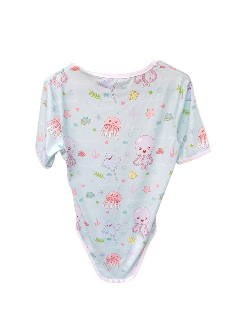 Adult bodysuit featuring colorful ocean creatures, including fish, jellyfish, stingrays, octopus and coral designs, perfect for a fun and cozy underwater-inspired look.