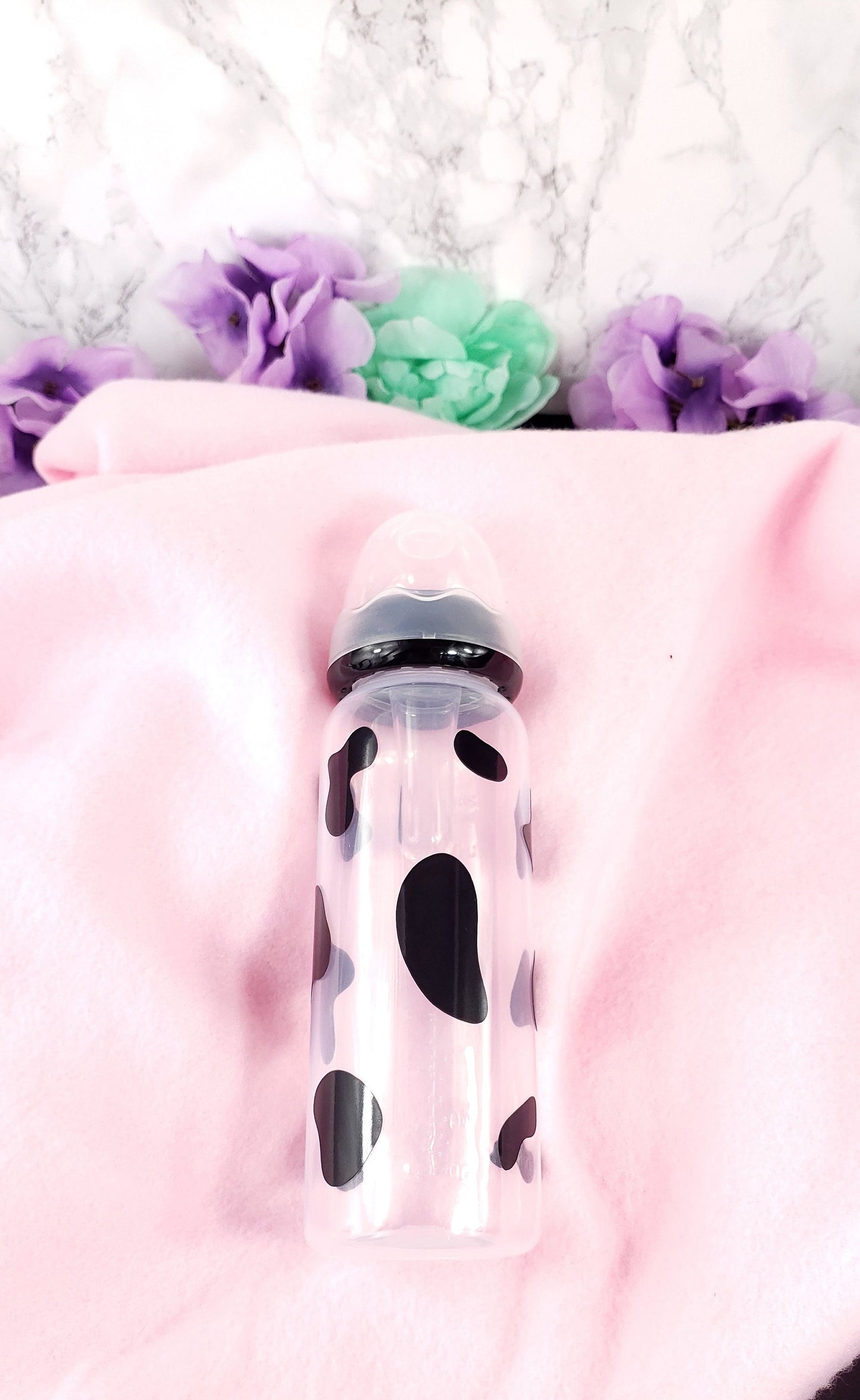 An 8oz adult baby bottle featuring a bold black cow spots pattern, creating a fun and farm-inspired design.