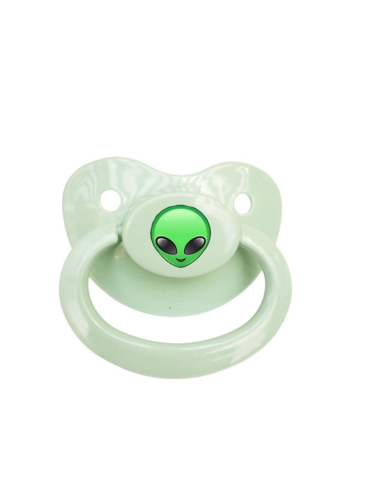 Green alien-themed adult pacifier featuring a cute alien face design and a matching silicone nipple for comfort and style.