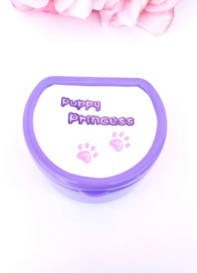 Adult pacifier case featuring the text 'Puppy princess' on the lid with cute paw print accents, designed for stylish and convenient pacifier storage.